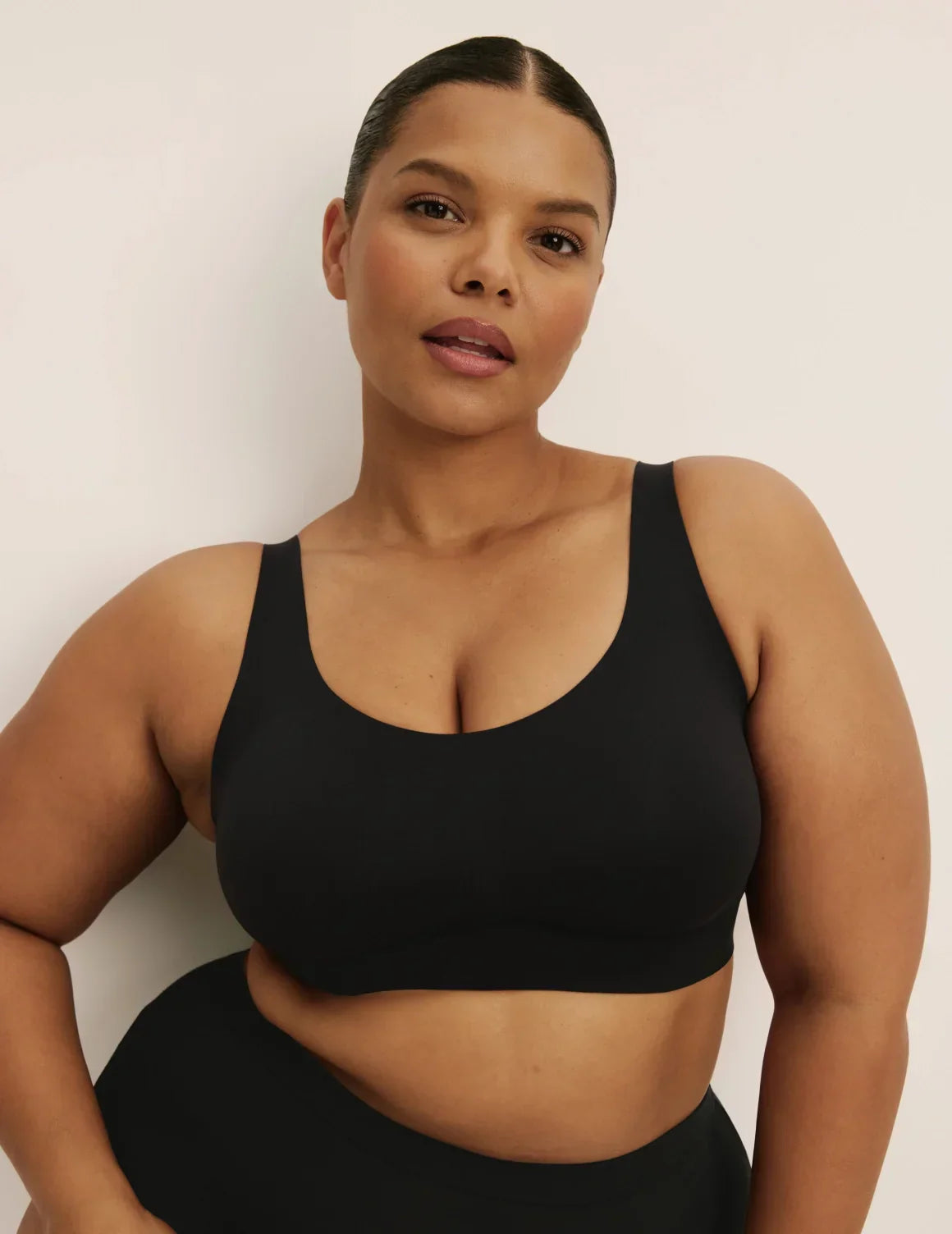 Front view of model wearing the Revolution Adjustable Pullover Bra, highlighting the neckline, strap design, and silhouette – Black – view 1 of 20