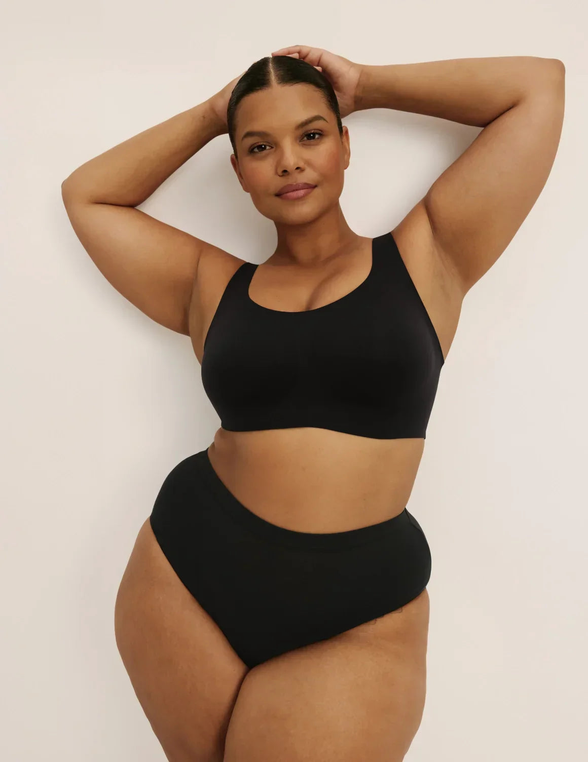 Full-body view of model wearing the Revolution Adjustable Pullover Bra, highlighting the neckline, strap design, and silhouette – Black – view 11 of 20