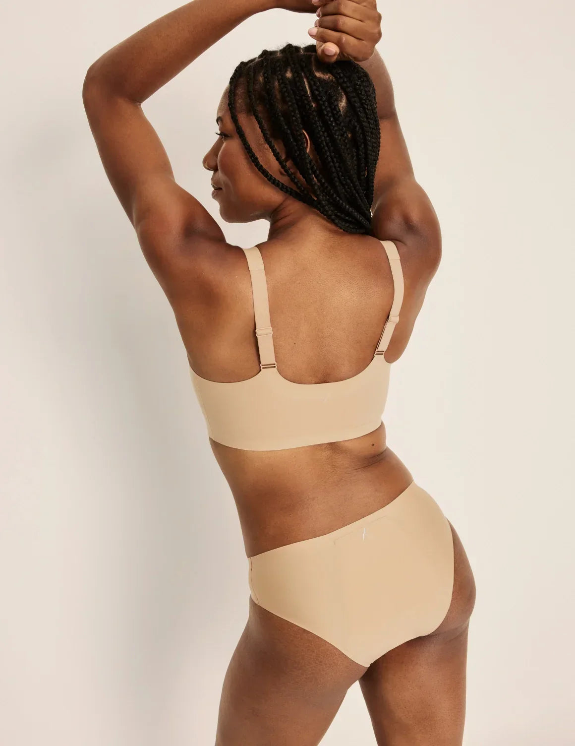 Back view of model wearing the Revolution Adjustable Pullover Bra, highlighting the neckline, strap design, and silhouette – Warm Sand – view 12 of 20