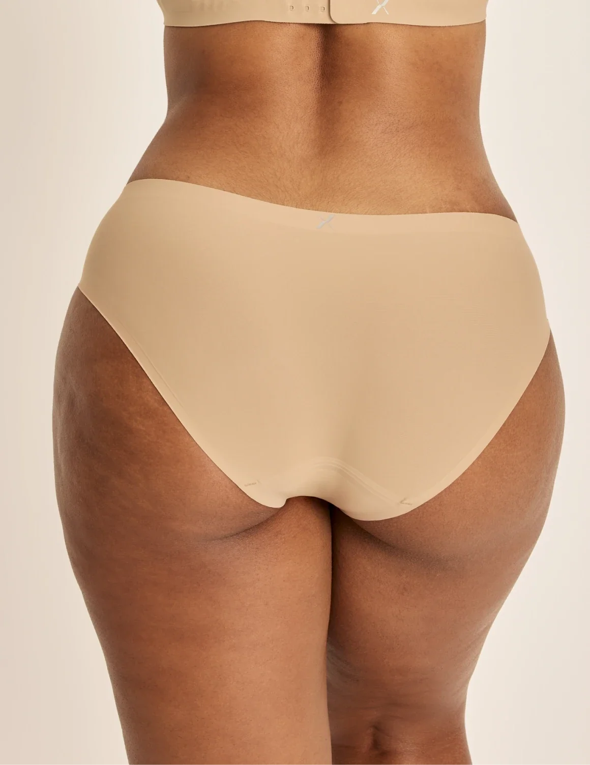 Back view of model wearing the Essential No-Show Bikini highlighting the coverage and smooth fit – Warm Sand – view 12 of 31