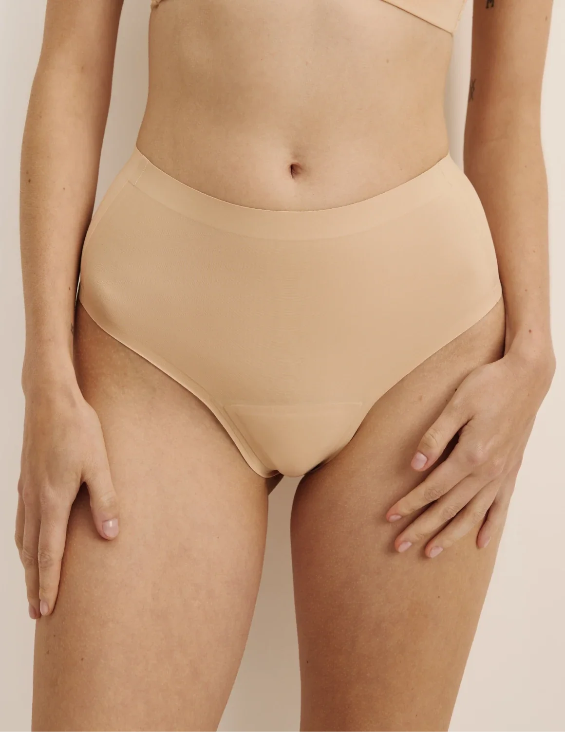 Front view of model wearing the Essential No-Show High Rise Thong highlighting the coverage and smooth fit – Warm Sand – view 5 of 8