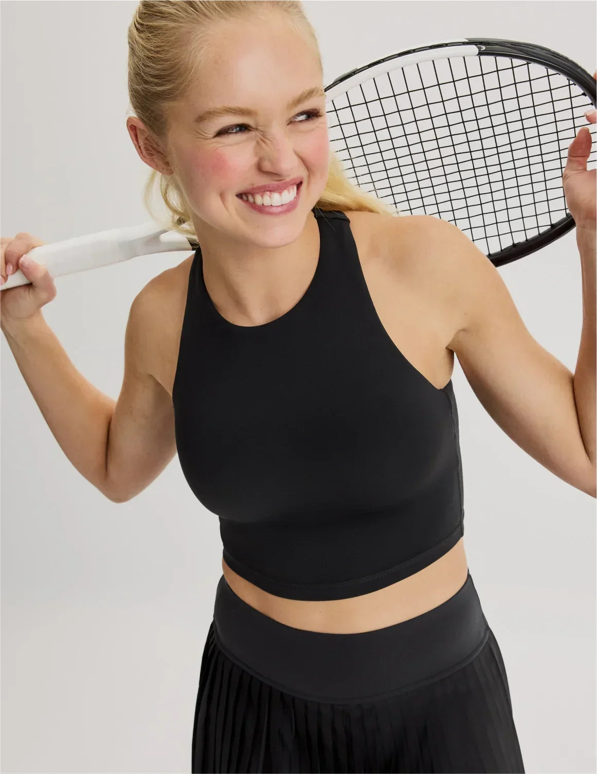 Front view of model wearing the Teen First Serve Racerback Tank highlighting the coverage and fit – Black – view 1 of 9