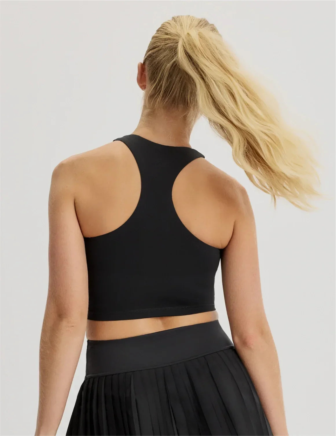 Back view of model wearing the Teen First Serve Racerback Tank highlighting the coverage and fit – Black – view 4 of 9