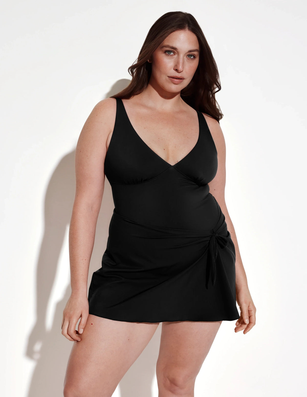 Front view of model wearing the Leakproof Sculpt Deep V Swim Dress highlighting the coverage and fit – Black – view 1 of 12