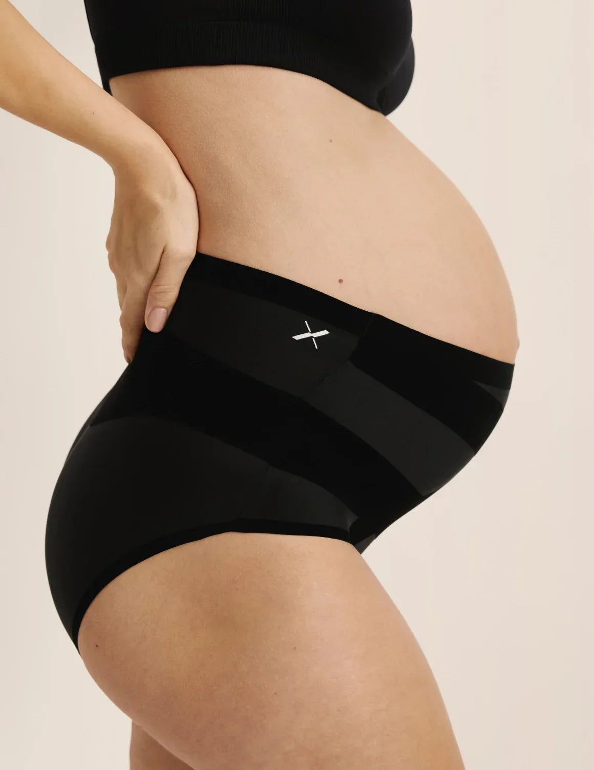 Side view of pregnant model wearing the Leakproof CoreLove High Rise, highlighting the coverage and hugging fit – Black – view 7 of 8