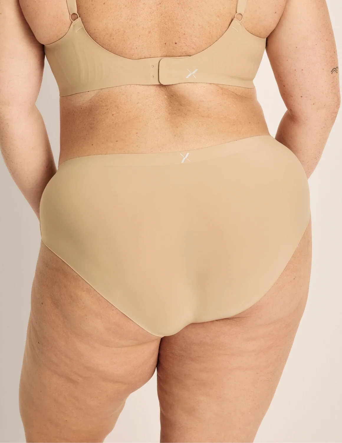 Back view of model wearing the Light Leakproof No-Show Boyshort highlighting the coverage and smooth fit – Warm Sand – view 12 of 17