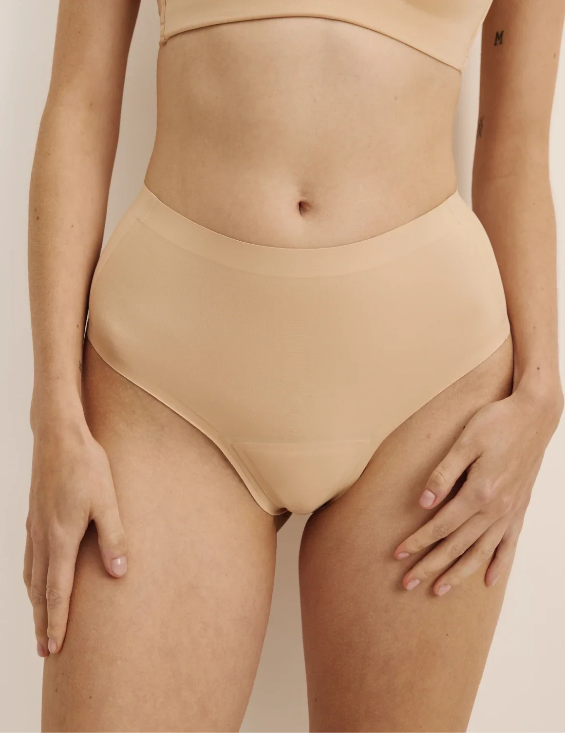 Front view of model wearing the Light Leakproof No-Show High Rise Thong highlighting the coverage and smooth fit – Warm Sand – view 5 of 9