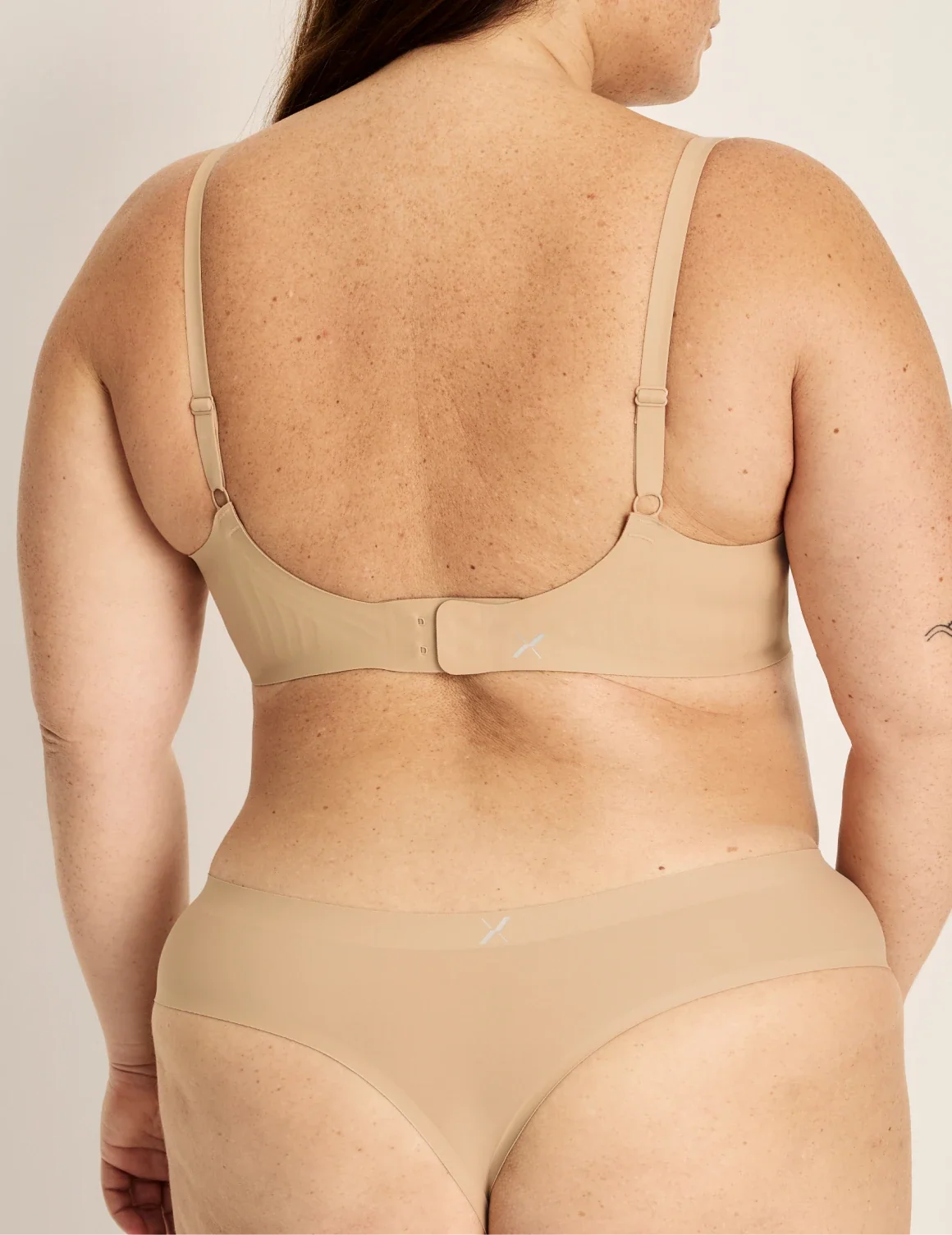 Back view of model wearing the Light Leakproof No-Show Thong highlighting the coverage and smooth fit – Warm Sand – view 7 of 9
