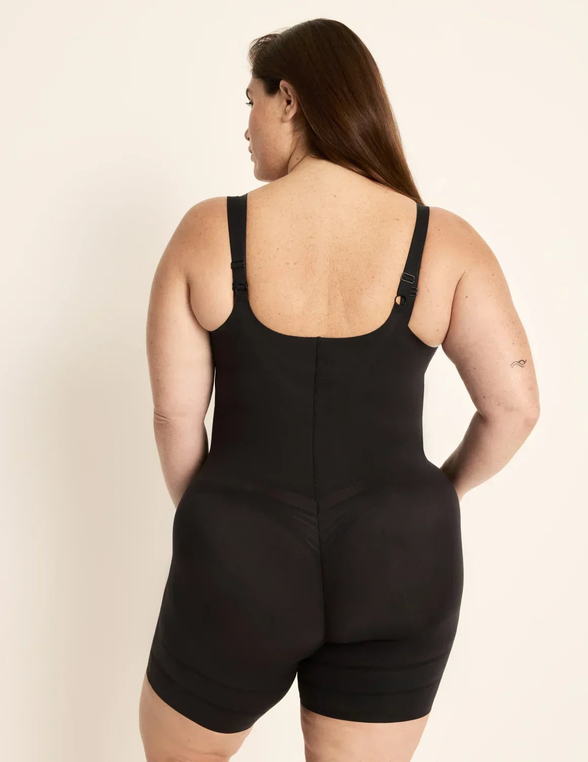 Back view of model wearing the Customizable Open Bust Shaper Bodysuit highlighting the coverage and smooth fit β Black β view 7 of 19
