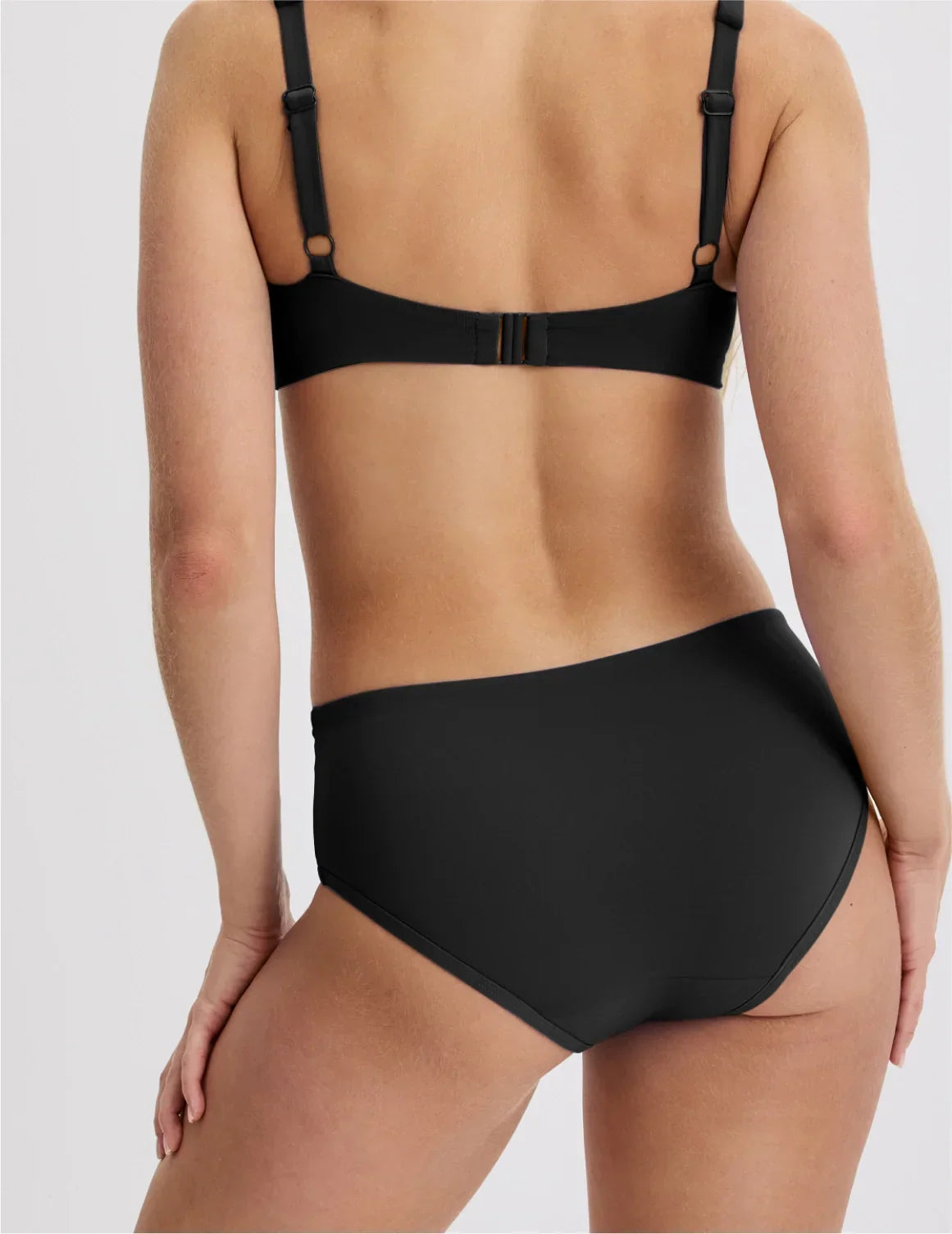 Back view of model wearing the Teen Period Swim Full-Coverage Bikini Bottom highlighting the coverage and fit – Black – view 11 of 70