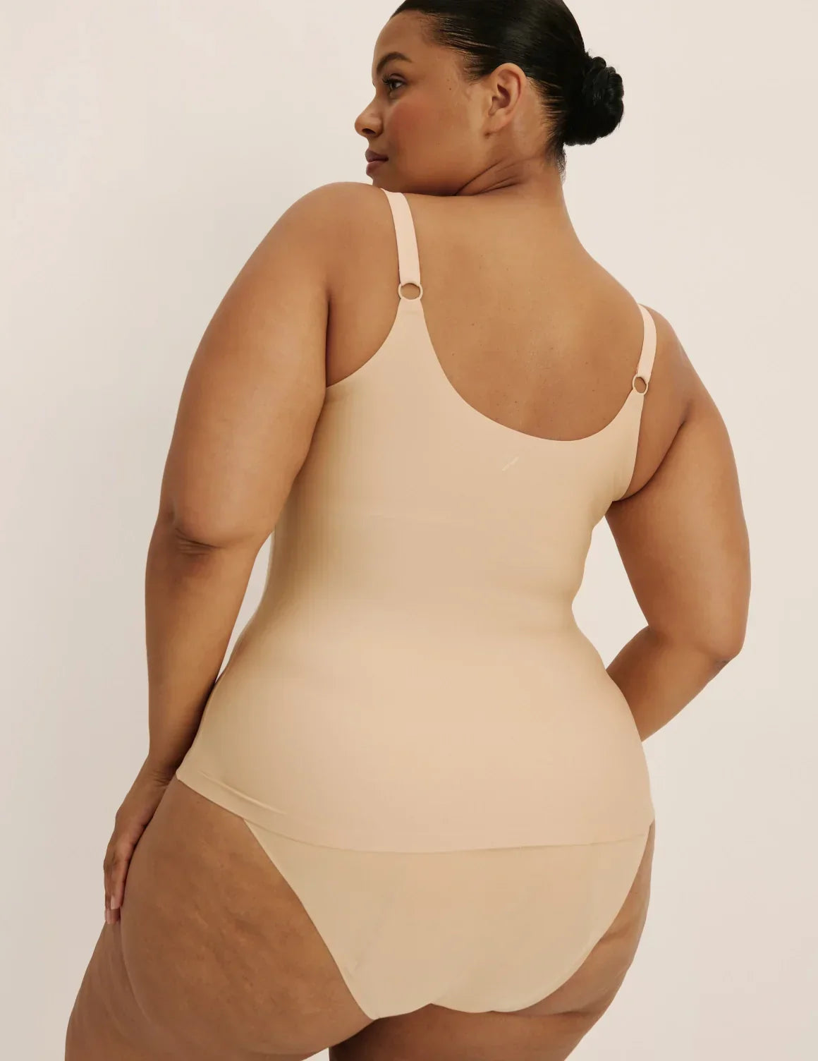 Back view of model wearing the Revolution Nursing Tank, highlighting the neckline, strap design, and smooth silhouette – Warm Sand – view 9 of 22