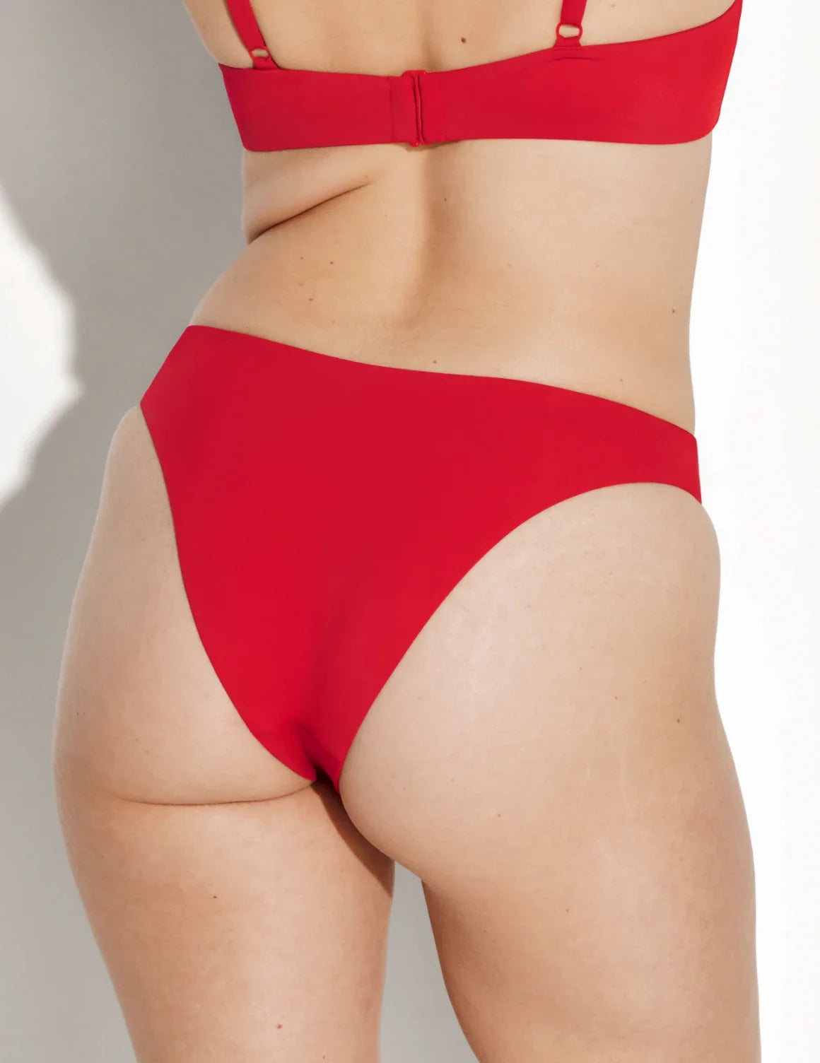 Back view of model wearing the Sculpt Dipped Bikini Swim Bottom highlighting the coverage and fit – Cherry – view 8 of 8