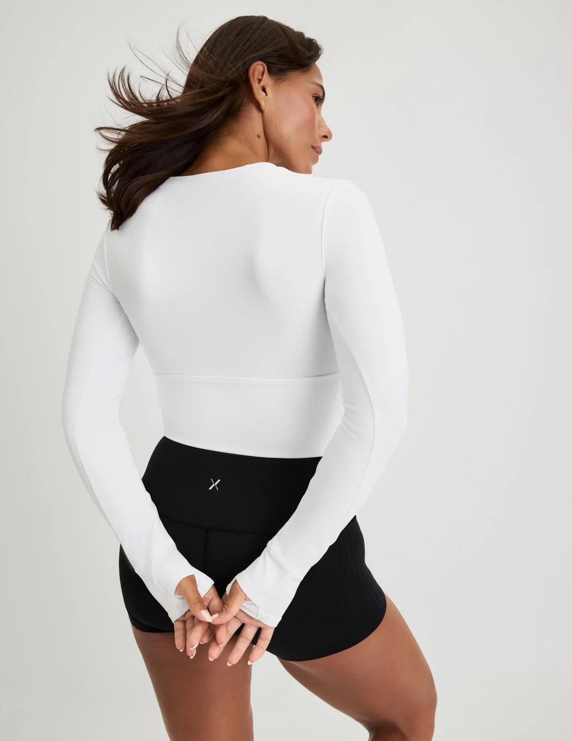 Back view of model wearing the Studio Cutout Bra Top, highlighting the keyhole neckline, flattering design, and silhouette – White – view 4 of 8