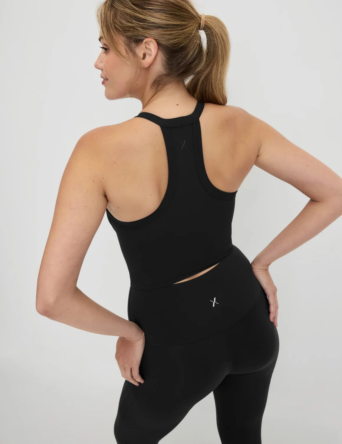 Back view of model wearing the Studio Ribbed Bra Top, highlighting the neckline, design, and silhouette – Black – view 5 of 19