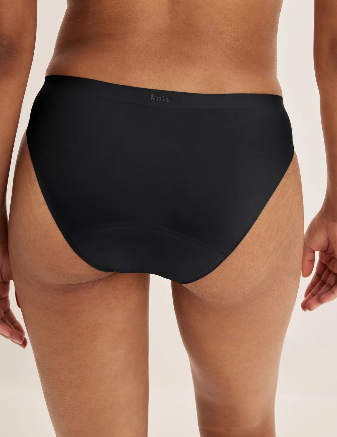 Back view of model wearing the Super Leakproof® No-Show Bikini highlighting the coverage and smooth fit – Black – view 3 of 29