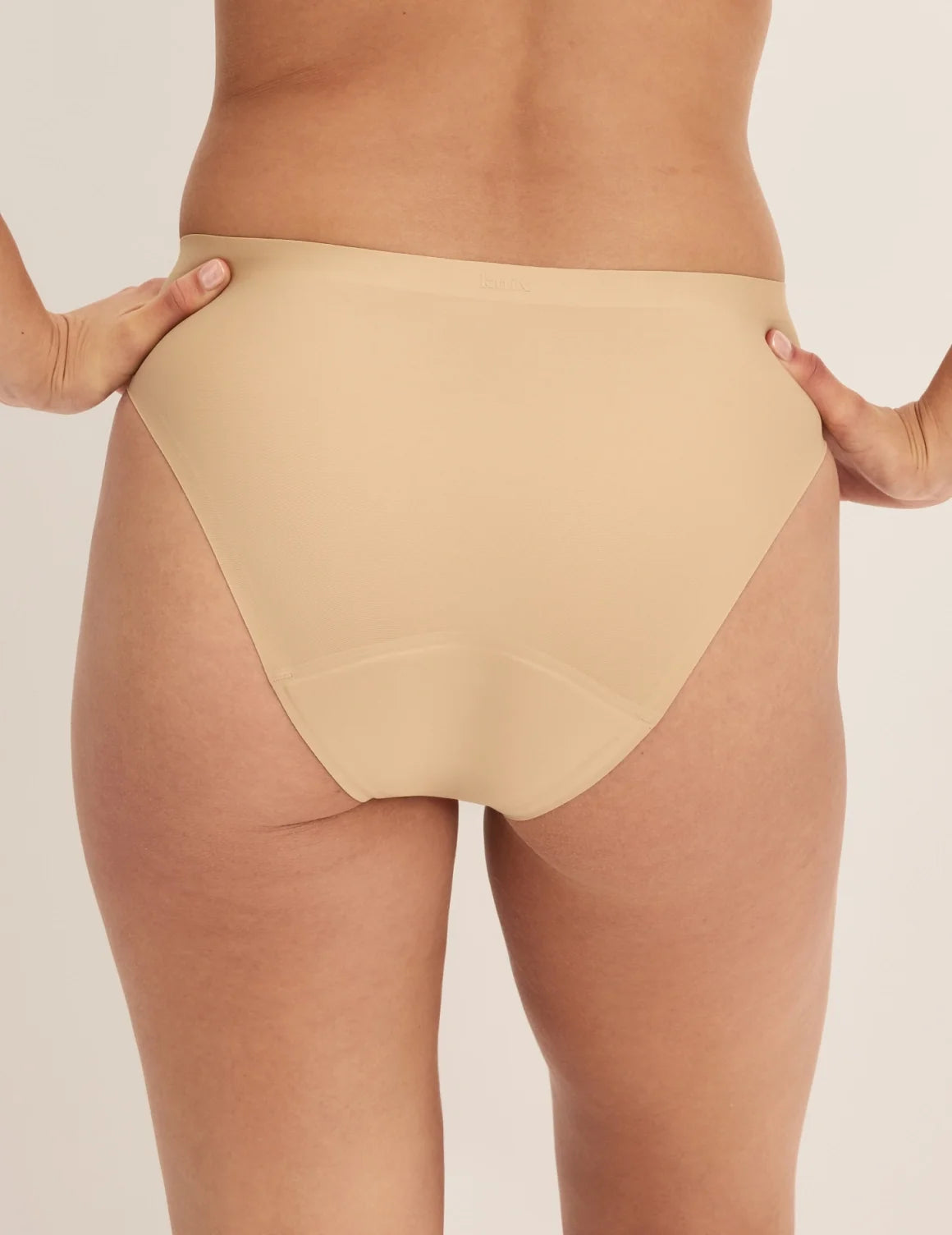 Back view of model wearing the Super Leakproof® No-Show French Cut highlighting the coverage and smooth fit – Warm Sand – view 9 of 27