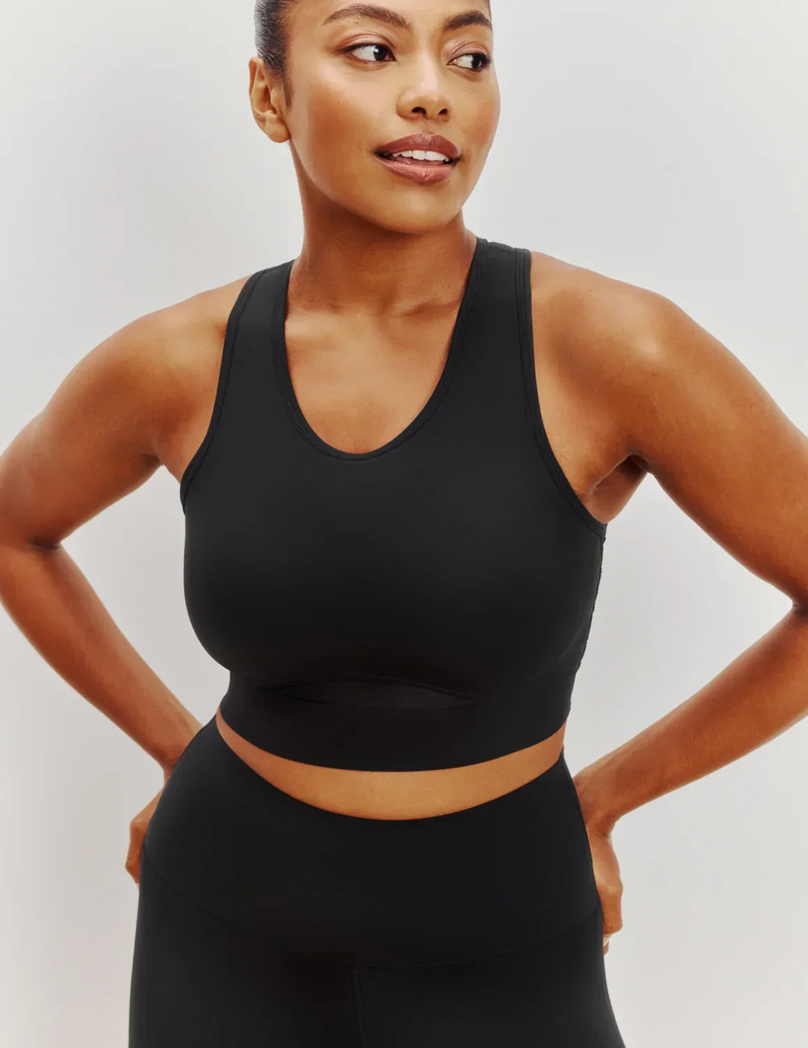 Front view of model wearing the Momenta Racerback Sports Bra, highlighting the neckline, strap design, and silhouette – Black – view 1 of 21