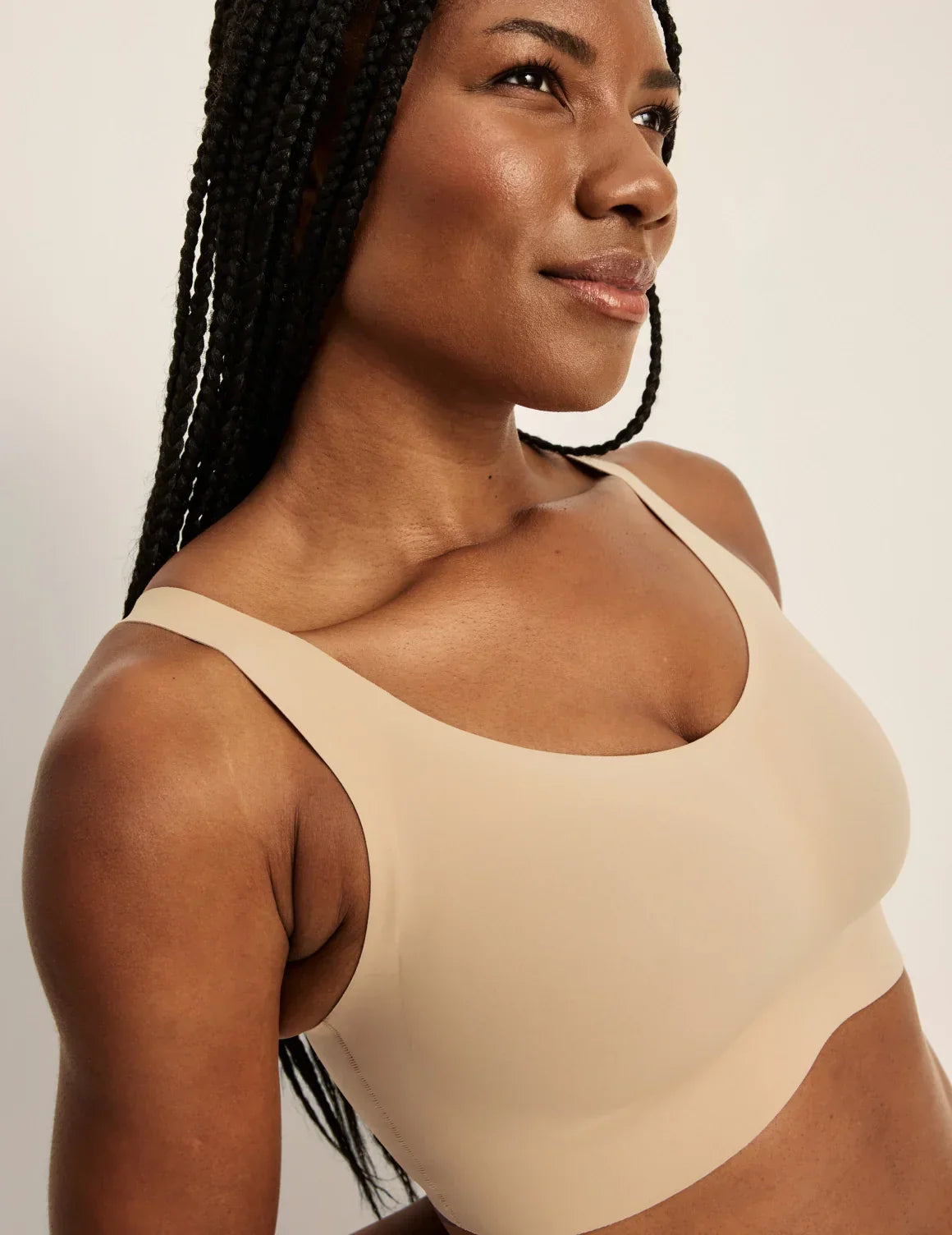 Front view of model wearing the Revolution Adjustable Pullover Bra, highlighting the neckline, strap design, and silhouette – Warm Sand – view 2 of 20