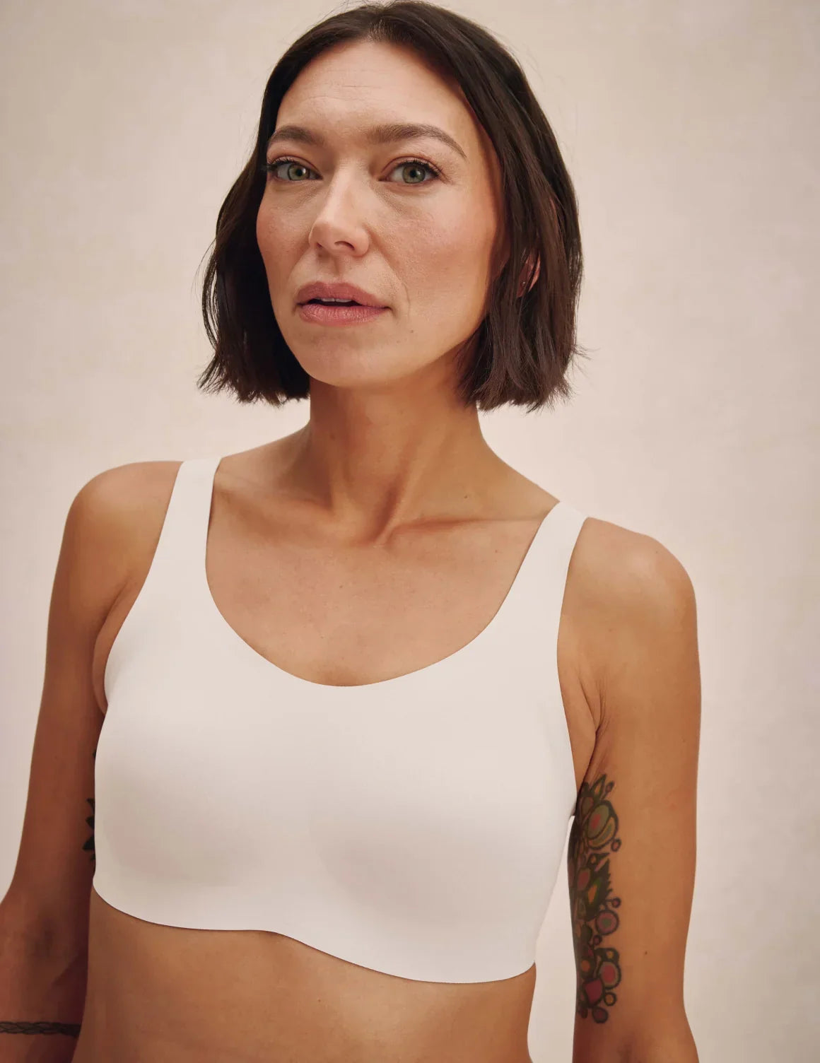 Front view of model wearing the Revolution Adjustable Pullover Bra, highlighting the neckline, strap design, and silhouette – White – view 6 of 20