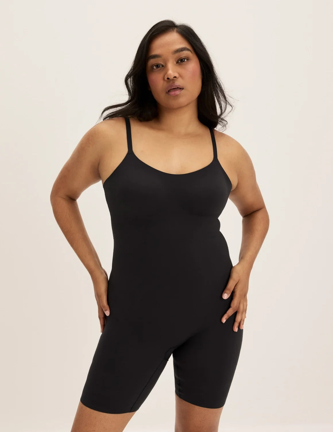 Front view of model wearing the Customizable Shaper Mid-Thigh Bodysuit highlighting the coverage and smooth fit – Black – view 1 of 11