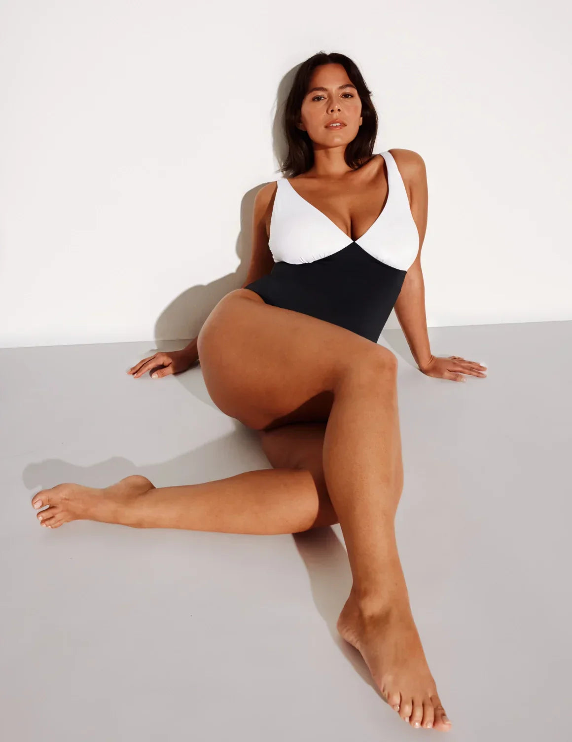 Front view of model wearing the Deep V One Piece Swimsuit highlighting the neckline, coverage and fit – Black/White – view 7 of 9