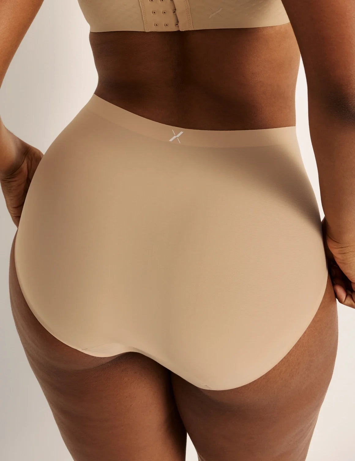 Back view of model wearing the Essential No-Show High Rise highlighting the coverage and smooth fit – Nude Multi – view 5 of 16