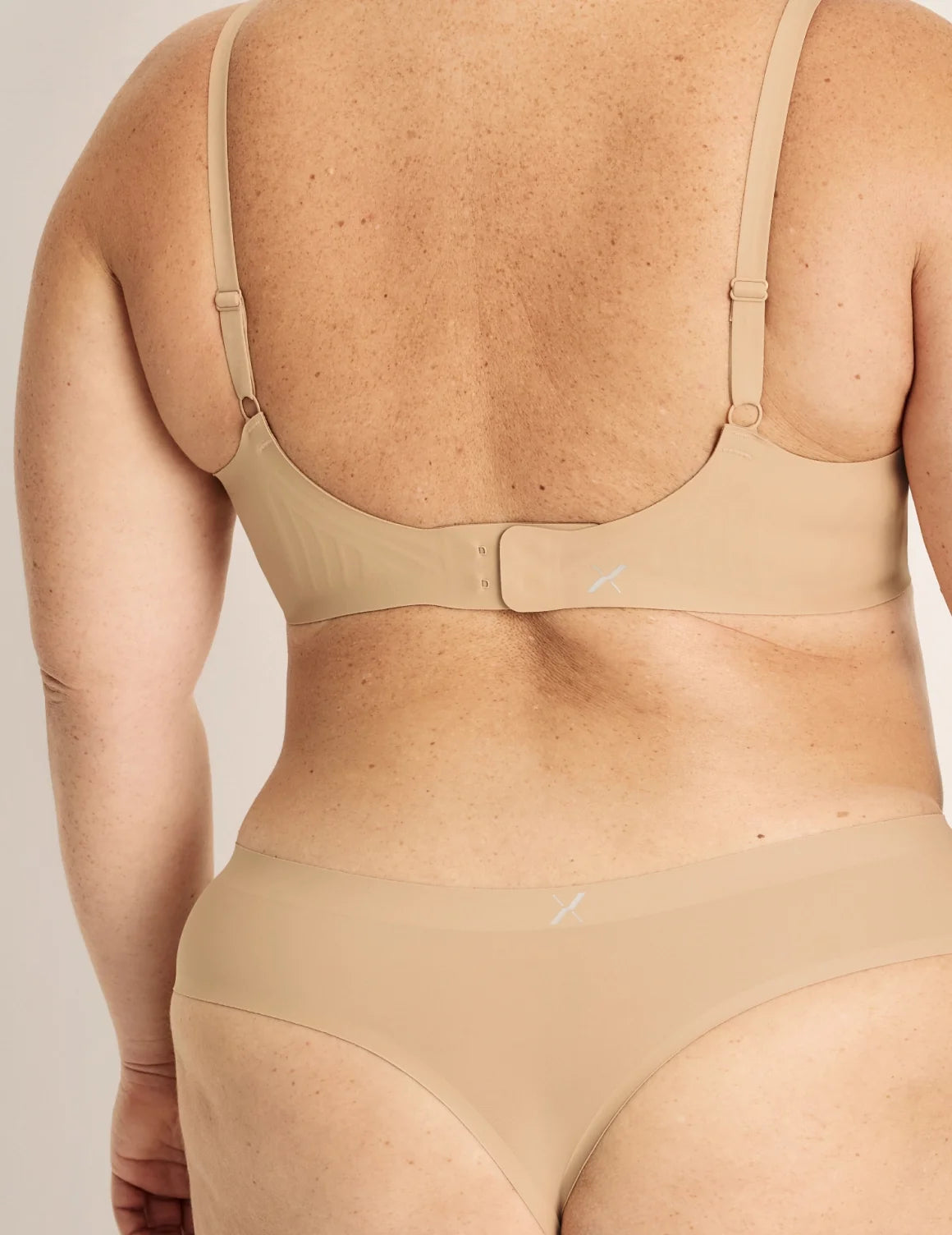 Back view of model wearing the Essential No-Show Thong highlighting the coverage and smooth fit – Nude Multi – view 5 of 18