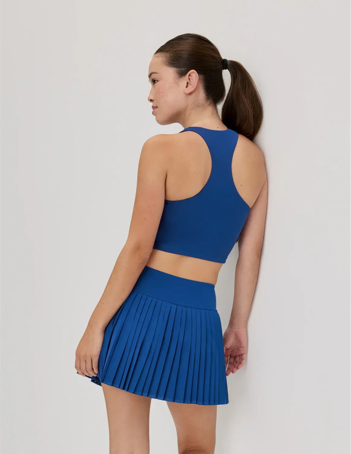 Back view of model wearing the Teen First Serve Racerback Tank highlighting the coverage and fit – Shady Blue – view 5 of 9