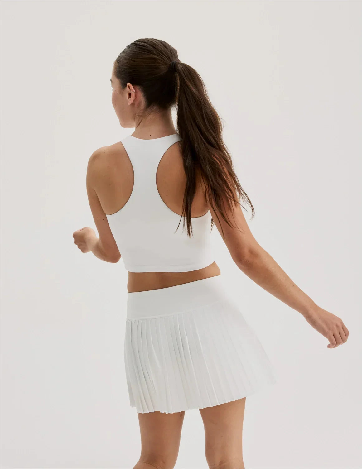 Back view of model wearing the Teen First Serve Racerback Tank highlighting the coverage and fit – White – view 6 of 9