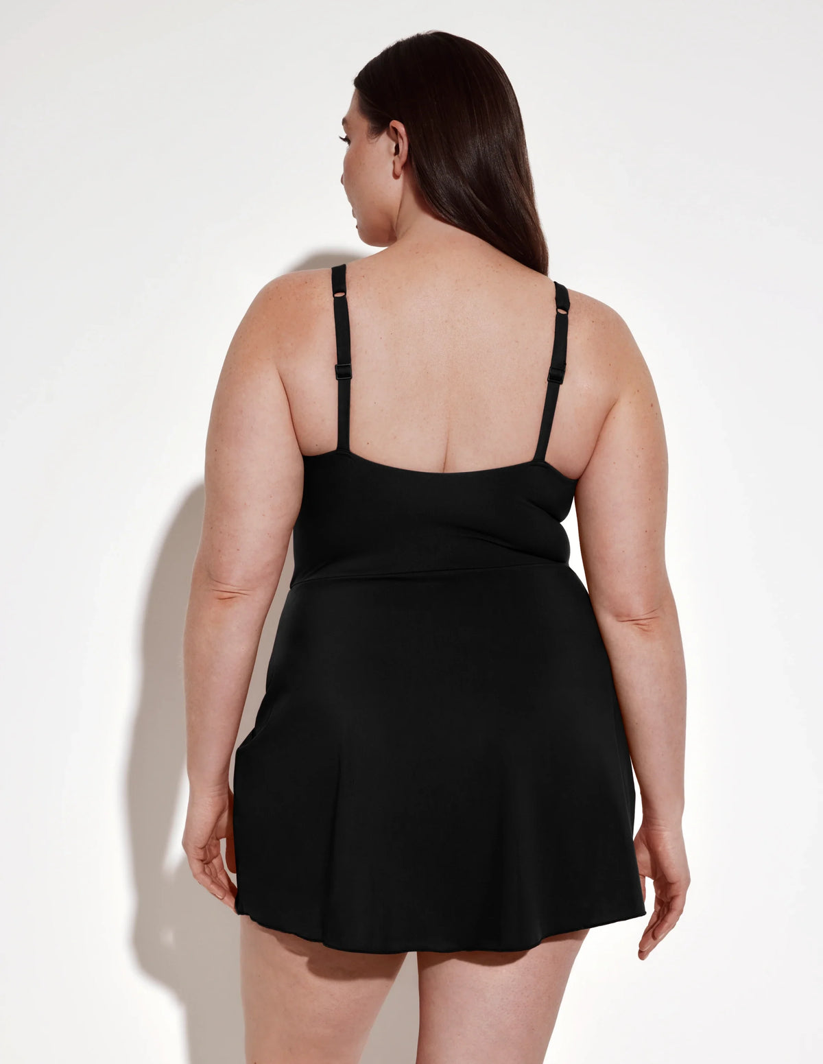 Back view of model wearing the Leakproof Sculpt Deep V Swim Dress highlighting the coverage and fit – Black – view 3 of 12