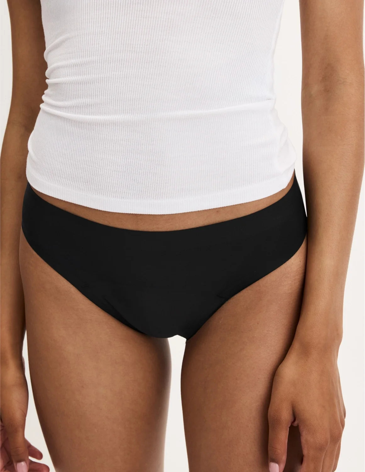 Front view of model wearing the Teen Leakproof UltraThin No-Show Thong highlighting the coverage and smooth fit – Black – view 8 of 34