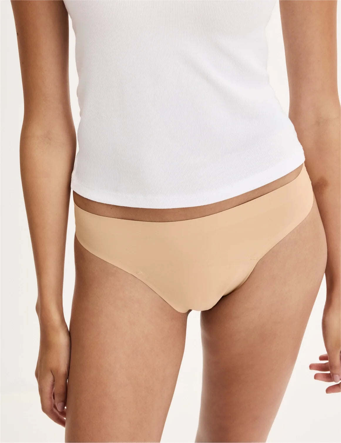 Front view of model wearing the Teen Leakproof UltraThin No-Show Thong highlighting the coverage and smooth fit – Warm Sand – view 6 of 34