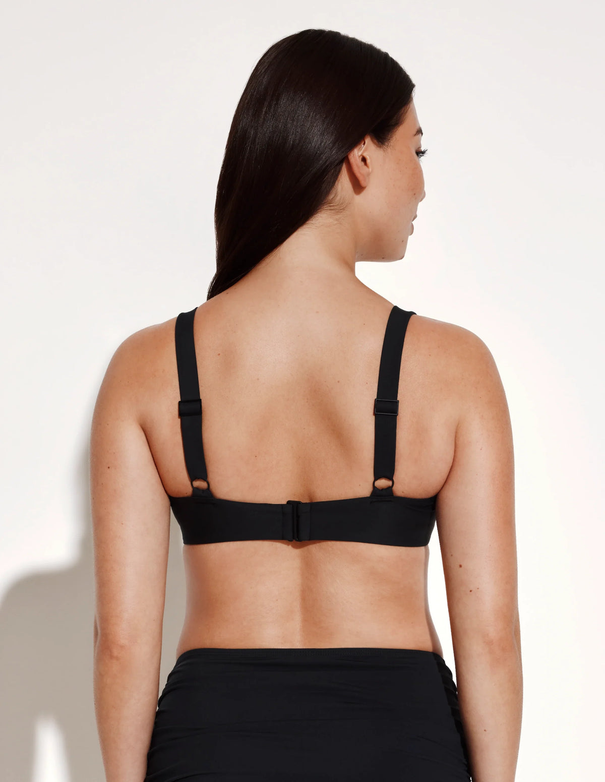 Back view of model wearing the Limited-Edition Sculpt Ruched Bikini Top, highlighting the neckline, strap design, and silhouette – Black – view 3 of 13