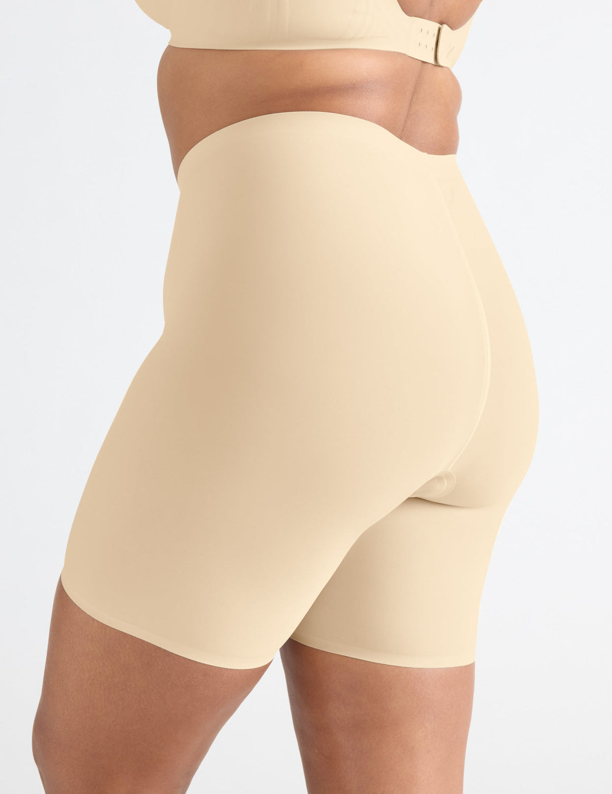 Side view of model wearing the Leakproof Thigh Saver® 6” highlighting the coverage and smooth fit – Dune – view 7 of 32