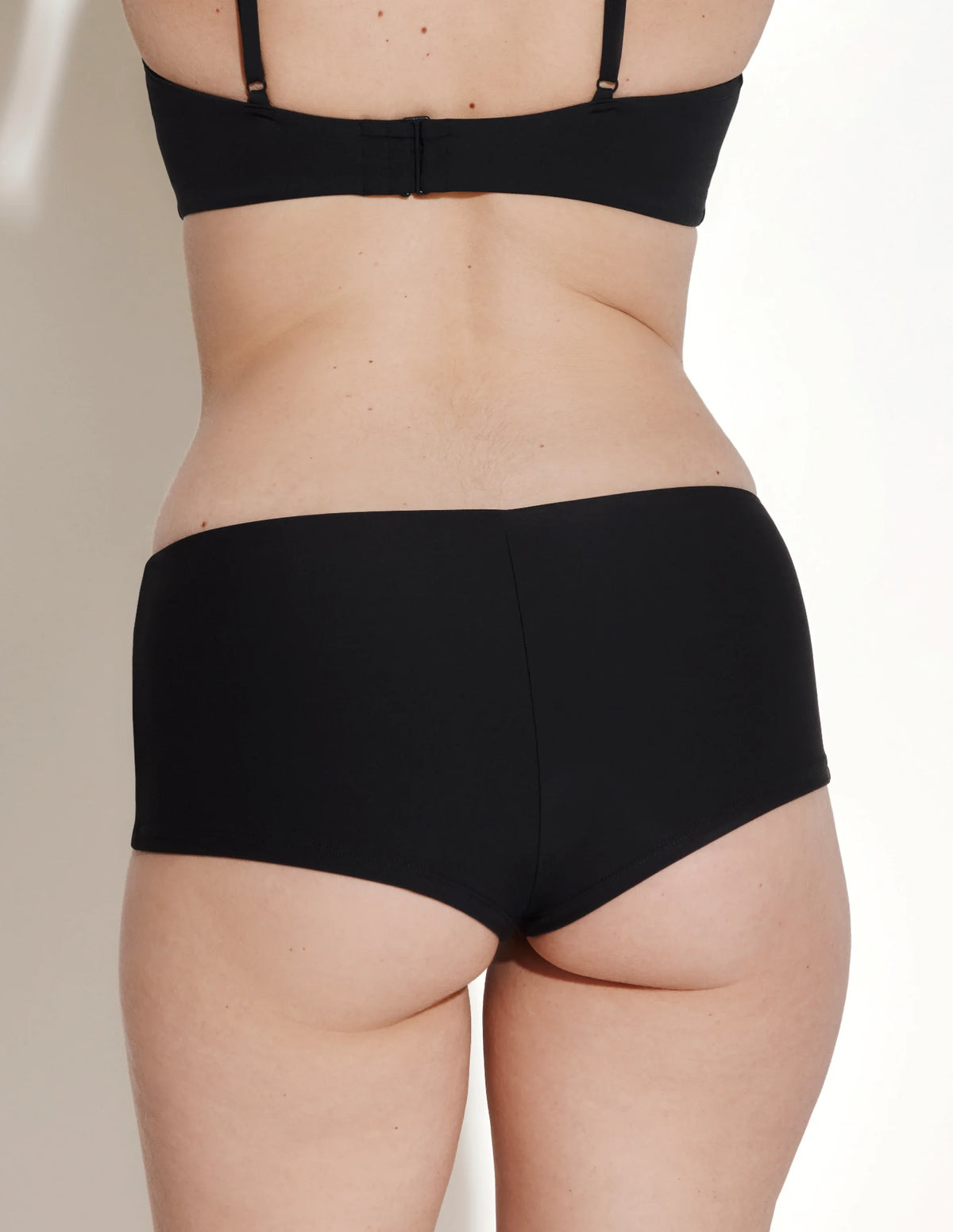 Back view of model wearing the Sculpt Cheeky Low Rise Swim Bottom highlighting the coverage and fit – Black – view 4 of 12