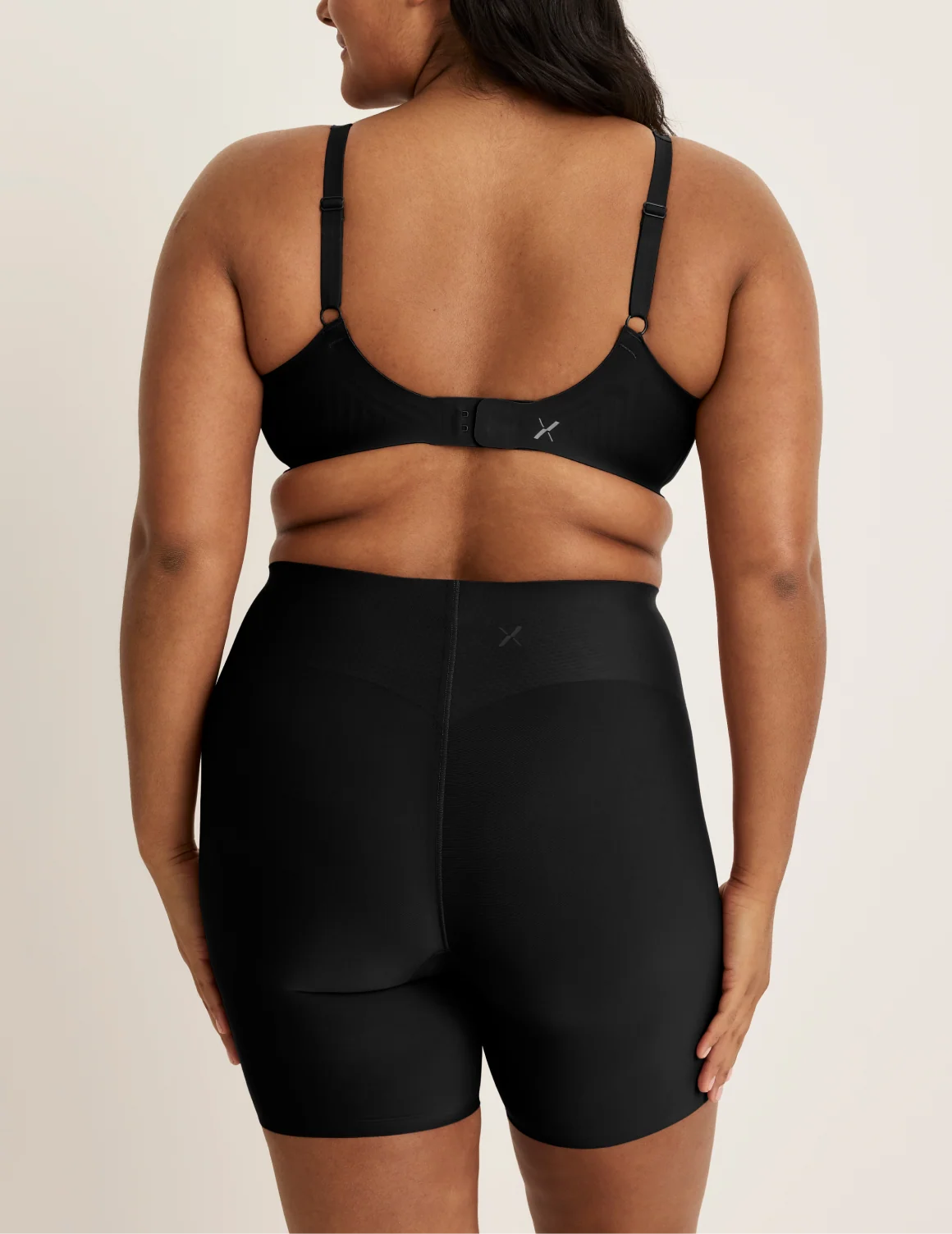 Back view of model wearing the Leakproof Contour Thigh Saver® 6”, highlighting the coverage and smooth fit – Black – view 7 of 19