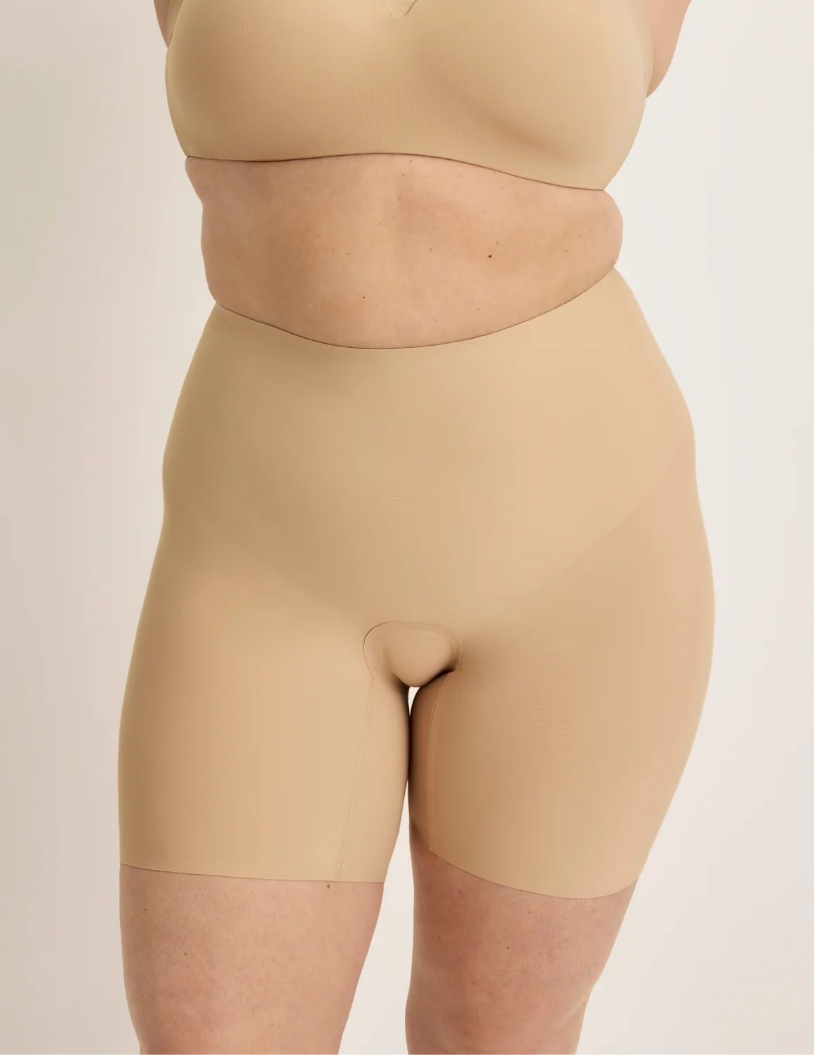 Front view of model wearing the Leakproof Contour Thigh Saver® 6”, highlighting the coverage and smooth fit – Warm Sand – view 1 of 19