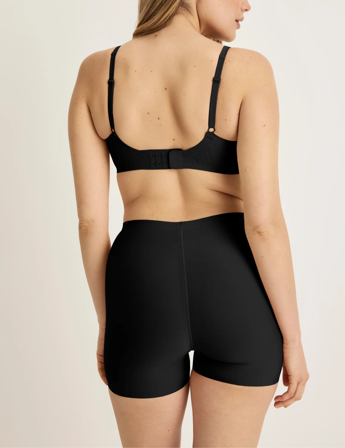 Back view of model wearing the Shortie Thigh Saver® 4”, highlighting the coverage and smooth fit – Black – view 4 of 25