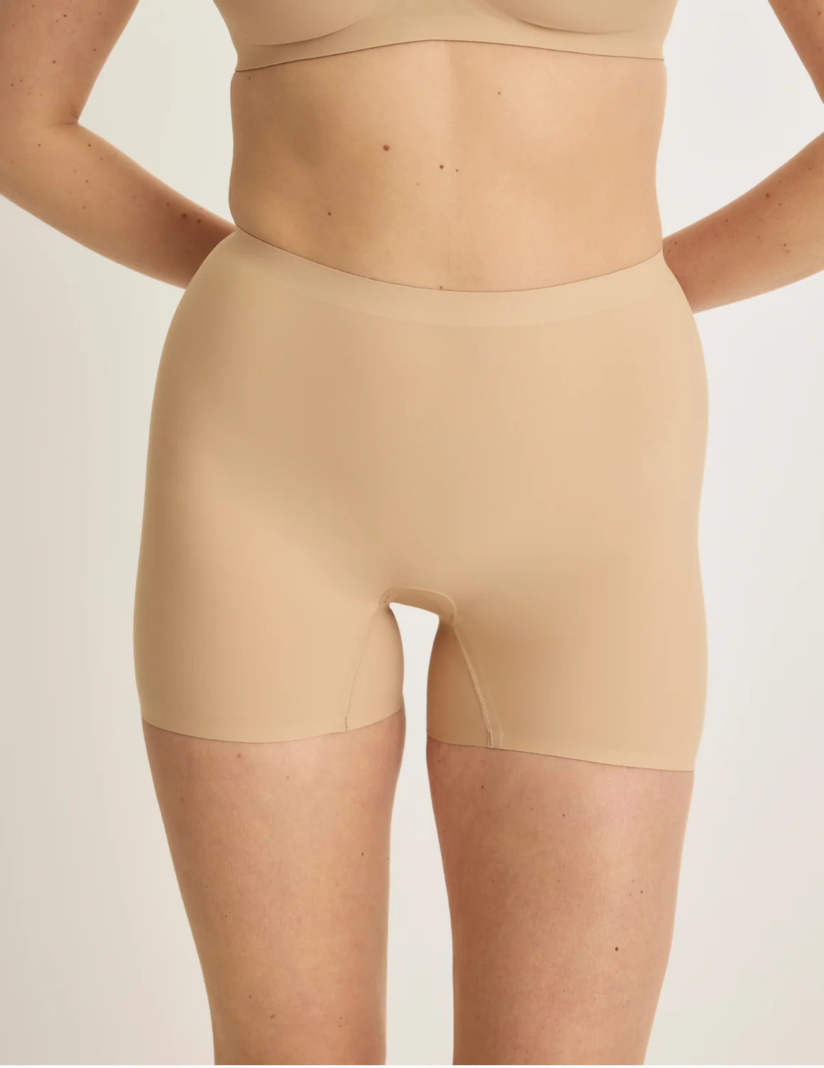 Front view of model wearing the Shortie Thigh Saver® 4”, highlighting the coverage and smooth fit – Warm Sand – view 12 of 25