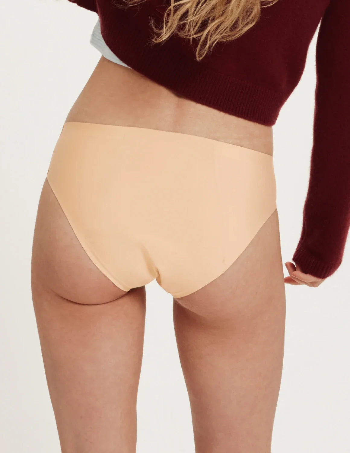 Back view of model wearing the Teen SuperPlus Leakproof® No-Show Bikini highlighting the coverage and smooth fit – Beige – view 9 of 16