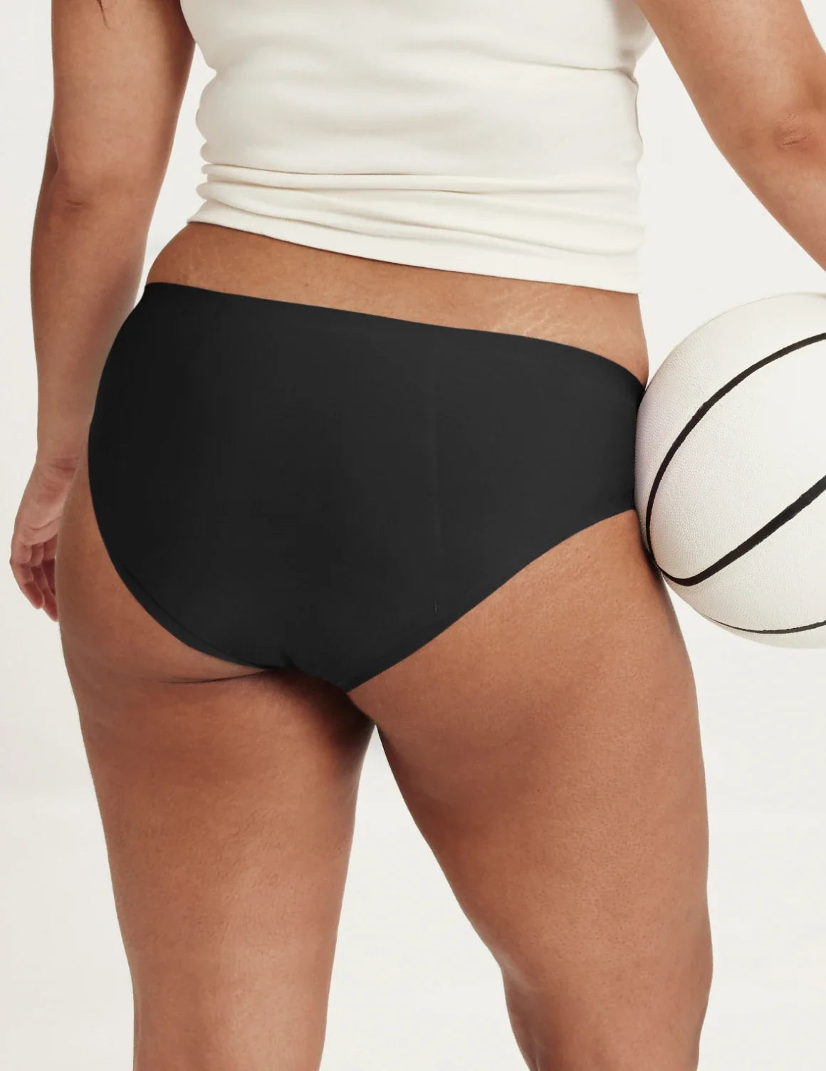 Back view of model wearing the Teen SuperPlus Leakproof® No-Show Bikini highlighting the coverage and smooth fit – Black – view 10 of 16