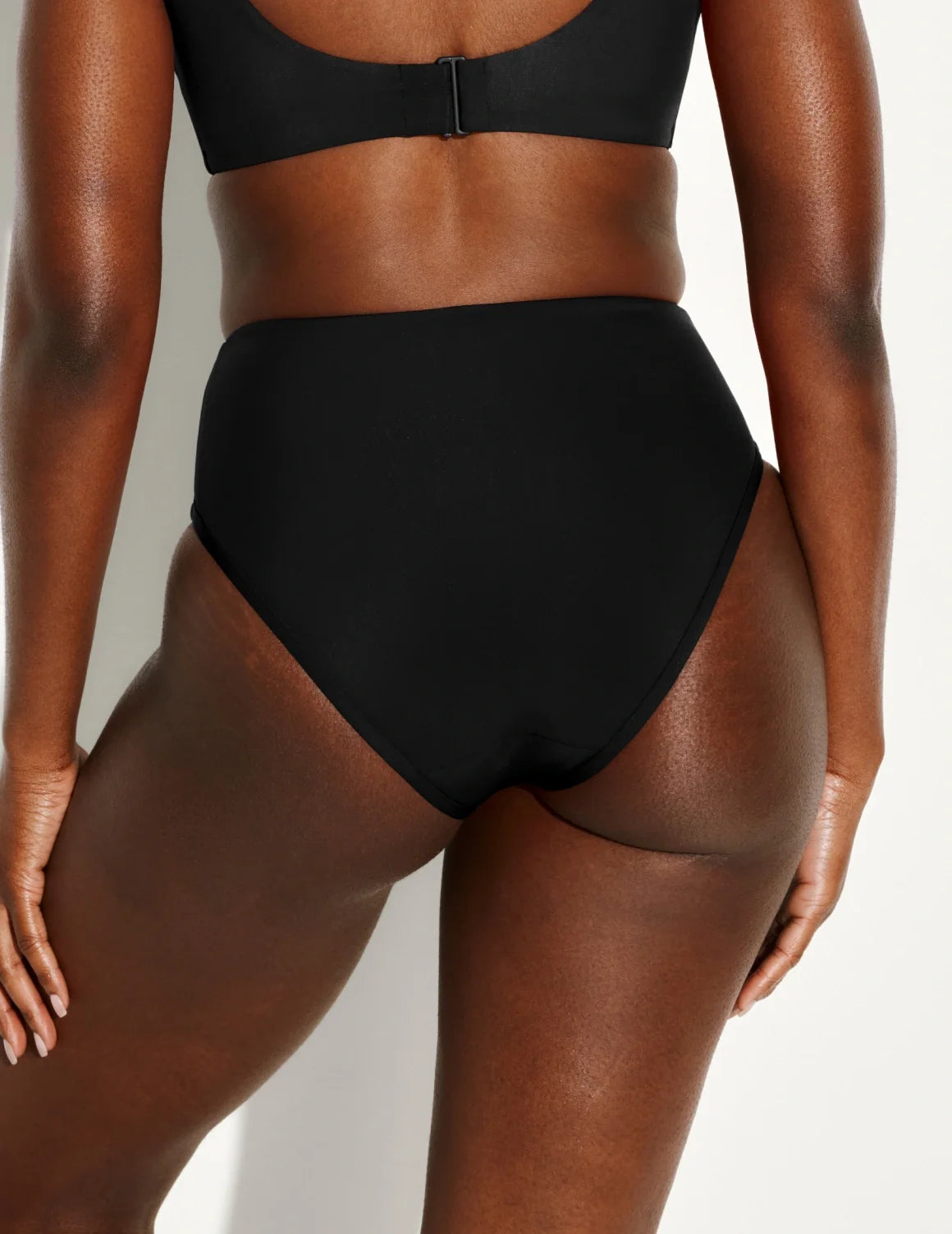 Back view of model wearing the Leakproof Sculpt High Rise Bikini Swim Bottom highlighting the coverage and fit – Black – view 11 of 21