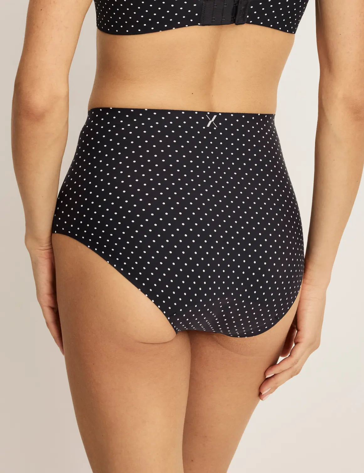 Back view of model wearing the Leakproof UltraThin No-Show High Rise highlighting the coverage and smooth fit – Black with White Polka Dot – view 3 of 40