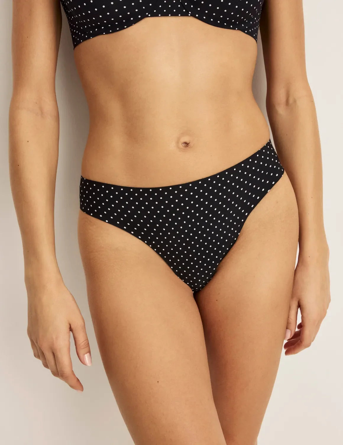 Front view of model wearing the Light Leakproof UltraThin No-Show Thong highlighting the coverage and smooth fit – Black with White Polka Dot – view 1 of 40