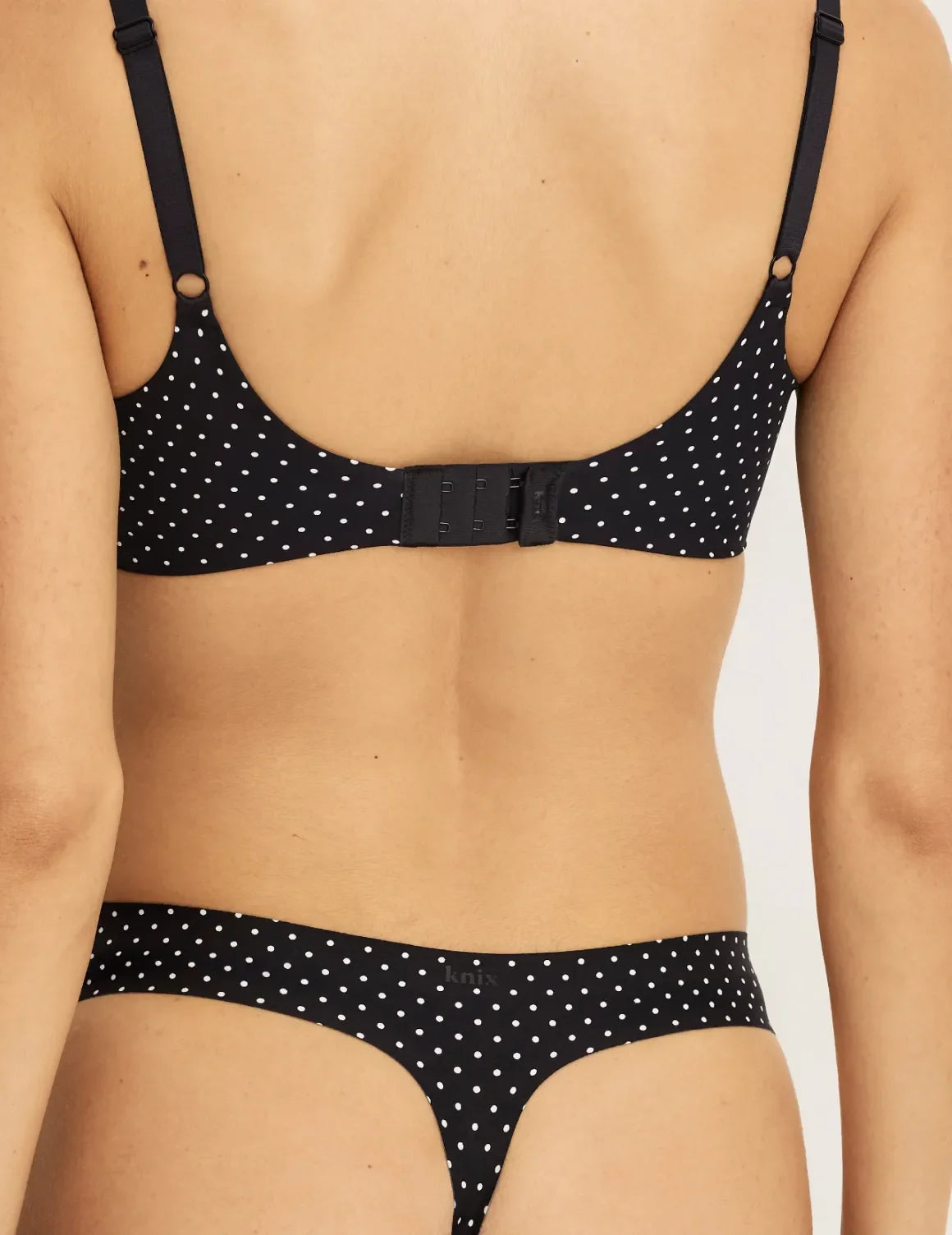 Back view of model wearing the Light Leakproof UltraThin No-Show Thong highlighting the coverage and smooth fit – Black with White Polka Dot – view 3 of 40