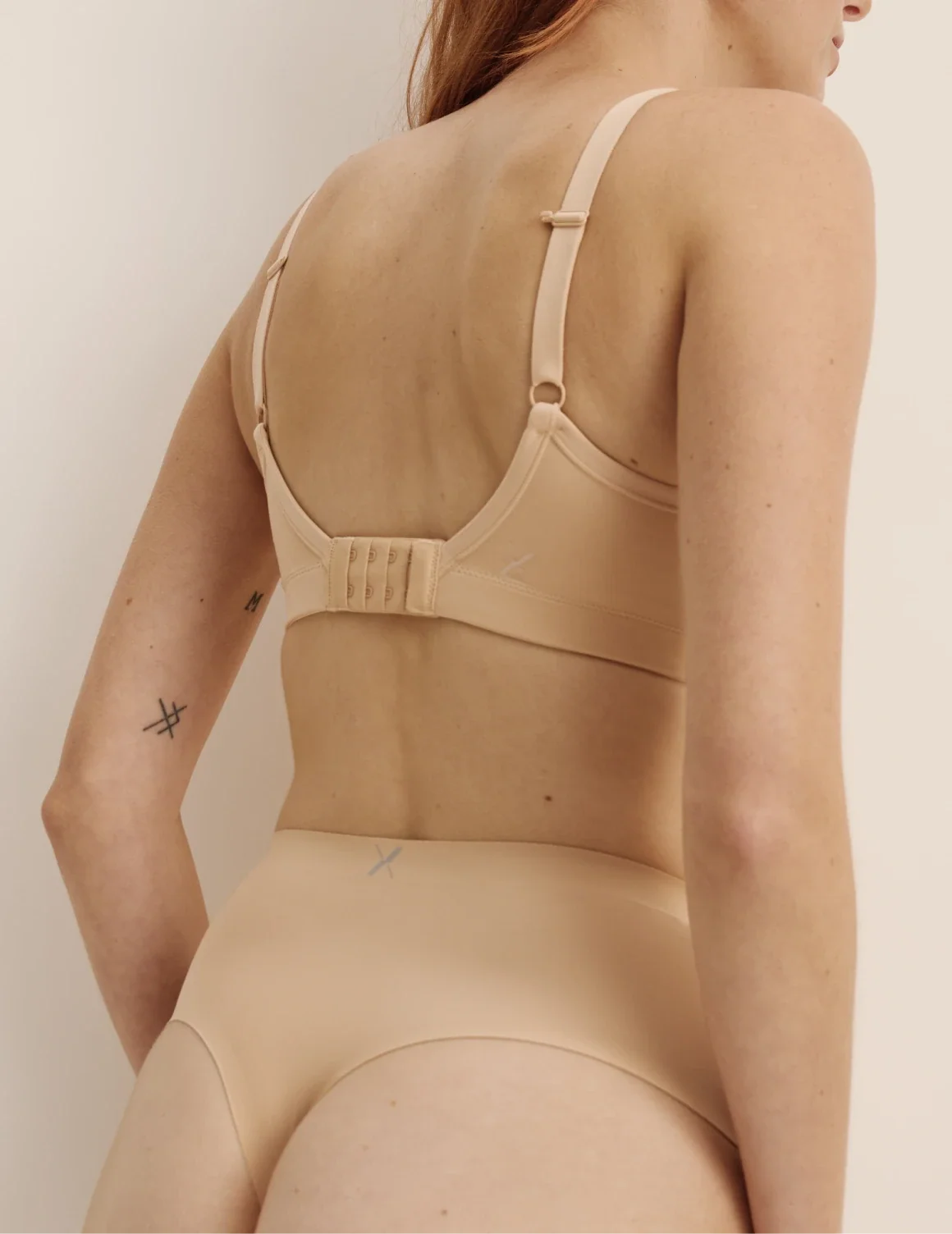 Back view of model wearing the Light Leakproof No-Show High Rise Thong highlighting the coverage and smooth fit – Warm Sand – view 7 of 9