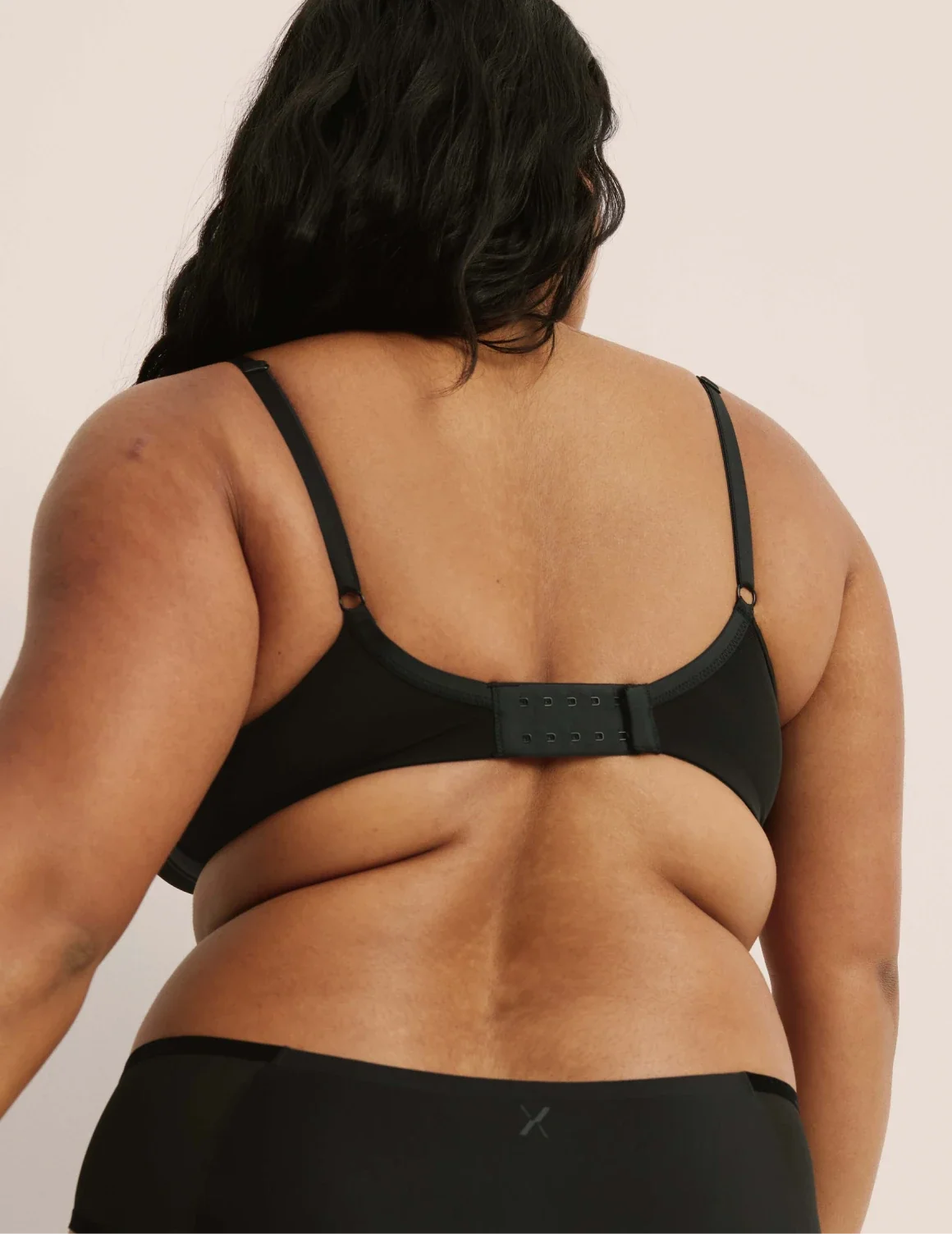 Back view of model wearing the Mesh Deep V Bra, highlighting the neckline, strap design, and smooth silhouette – Black – view 3 of 42