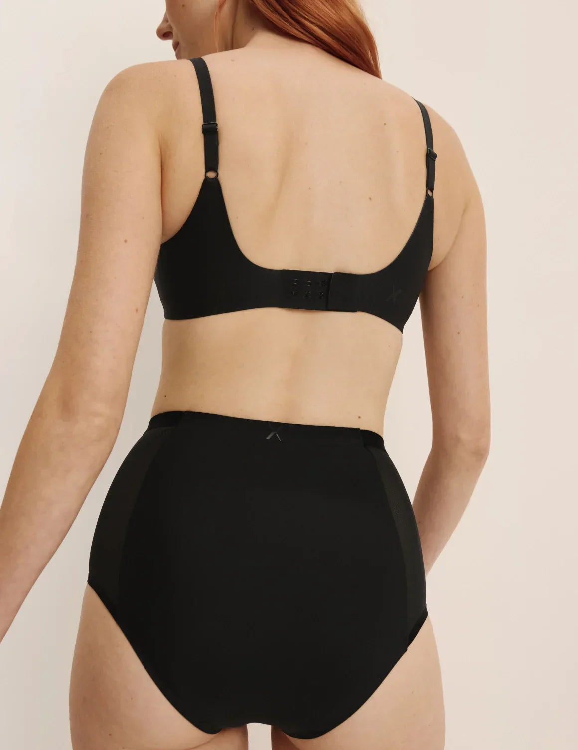Back view of model wearing the Revolution Shadow Mesh Bra, highlighting the neckline, strap design, and silhouette – Black – view 8 of 19