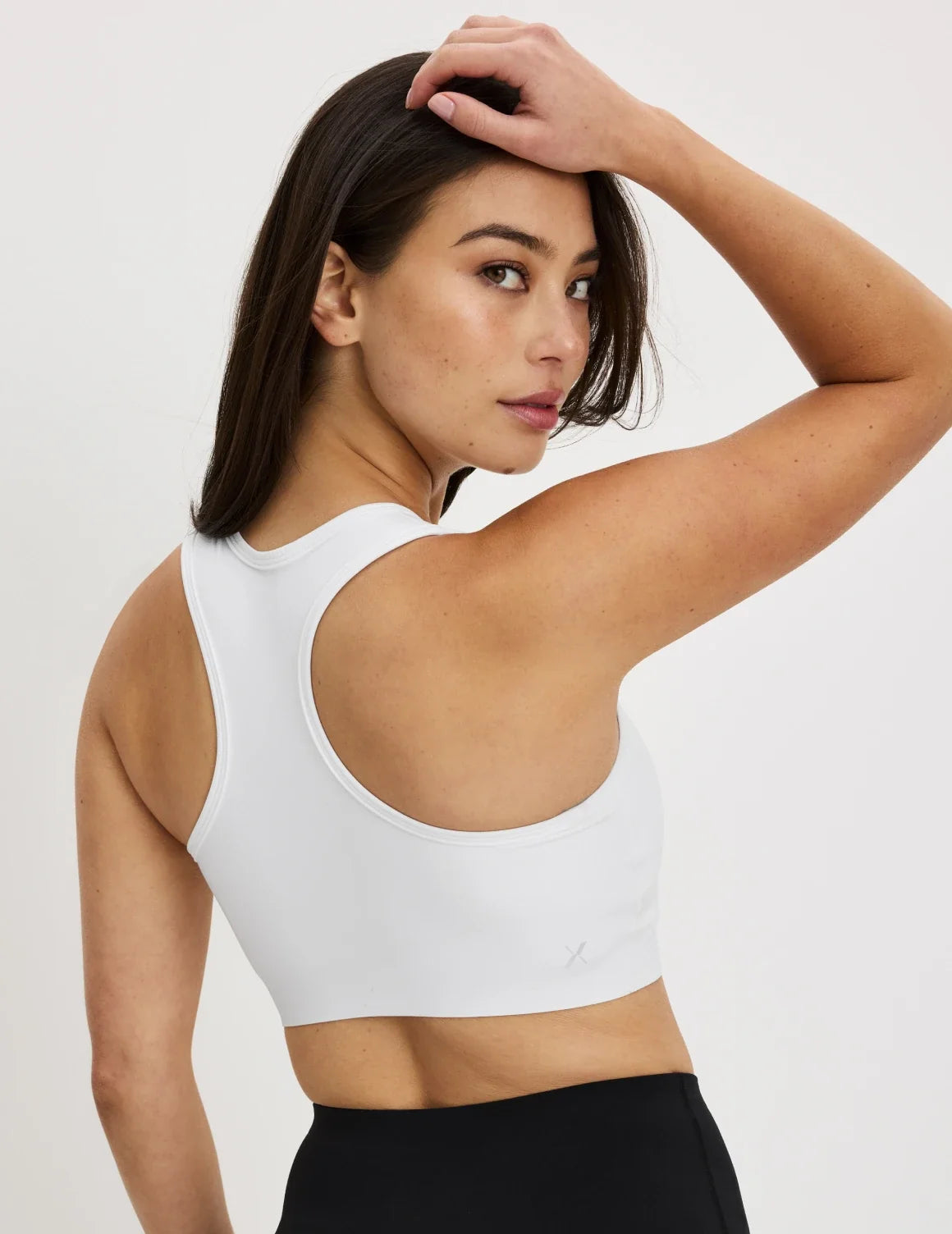 Back view of model wearing the Momenta Racerback Sports Bra, highlighting the neckline, strap design, and silhouette – Bright White – view 12 of 21