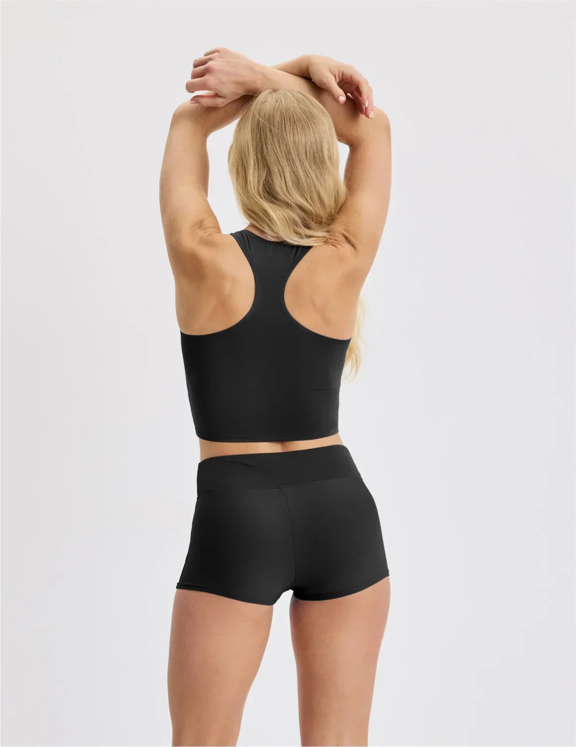 Back view of model wearing the Teen Racerback Tankini Swim Top highlighting the coverage and fit – Black – view 7 of 45